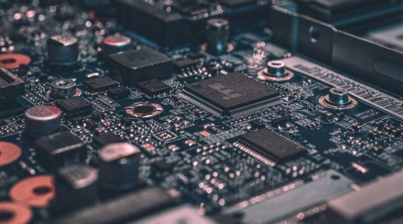 Close-up of a computer motherboard showing chips, capacitors, and circuit traces.